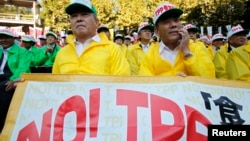 FILE - Farmers attend a rally against Japan participating in rule-making negotiations for the U.S.-led Trans-Pacific Partnership (TPP) in Tokyo.
