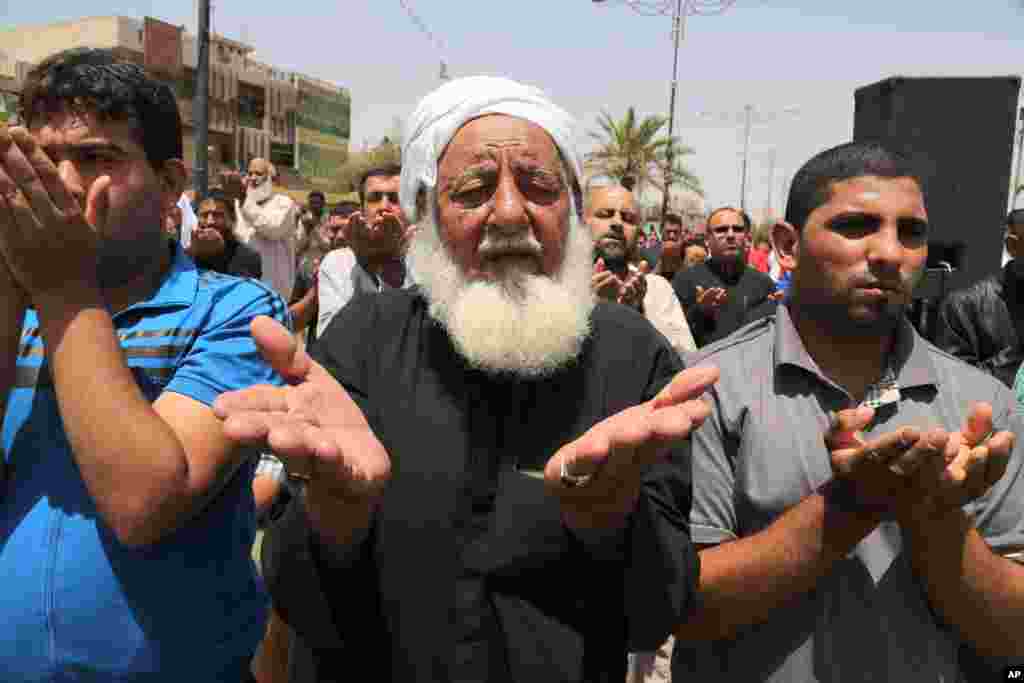 Followers of Shiite cleric Muqtada al-Sadr attend open-air Friday prayers in the Shiite stronghold of Sadr City, Baghdad, Iraq, July 18, 2014.