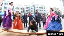 22일 대전 유성구 유성문화원에서 열린 '2016 유성 정월대보름제'에서 한복을 곱게 차려 입은 주민이 널뛰기를 하고 있다.