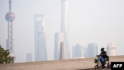 Một người đàn ông chạy xe máy trên đường phố Thượng Hải, Trung Quốc. 
