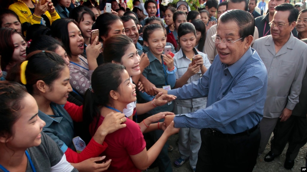 FILE - Cambodia's Prime Minister Hun Sen greets garment workers during a visit to the Phnom Penh Special Economic Zone on the outskirts of Phnom Penh, Cambodia, Aug. 23, 2017. Two Cambodian radio stations said they were being shut down, shrinking the space left for political activity and free expression ahead of next year’s general election.