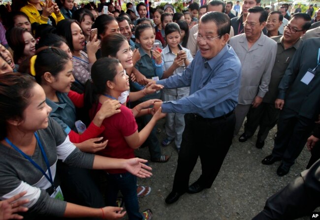 FILE - Cambodia's Prime Minister Hun Sen greets garment workers during a visit to the Phnom Penh Special Economic Zone on the outskirts of Phnom Penh, Cambodia, Aug. 23, 2017.