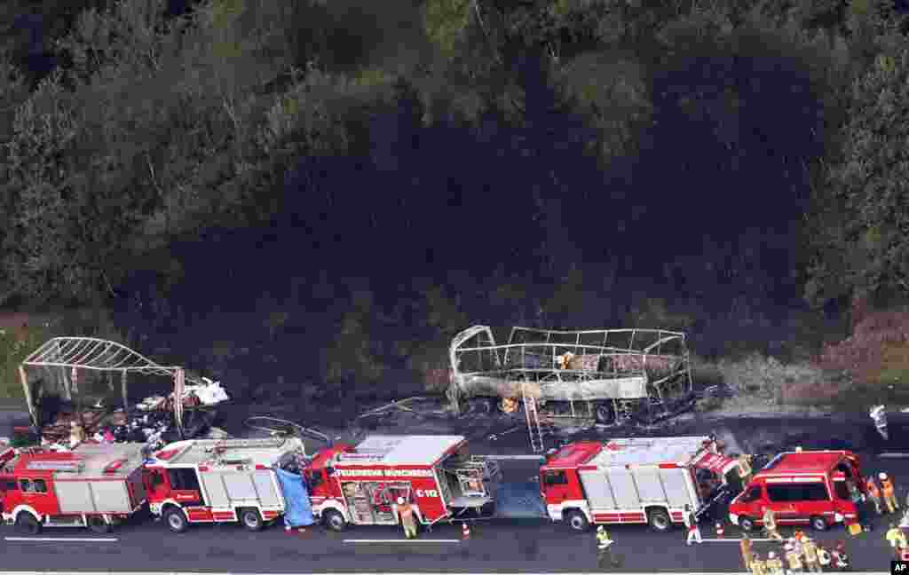 Emergency personnel work at the scene of a fatal accident on the motorway A9 near Muenchberg, Germany. A bus carrying German seniors on holiday slammed into the back of a truck that had slowed for a traffic jam and burst into flame, authorities said.