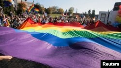 Participants display a large rainbow flag at the "Equality Parade" rally in support of the LGBT community in Lublin, Poland, Oct. 13, 2018. More than 200 Polish schools had planned to take part in “Rainbow Friday,” an anti-discrimination event set for Oct. 26, 2018, but some bowed out following government pressure and threats.