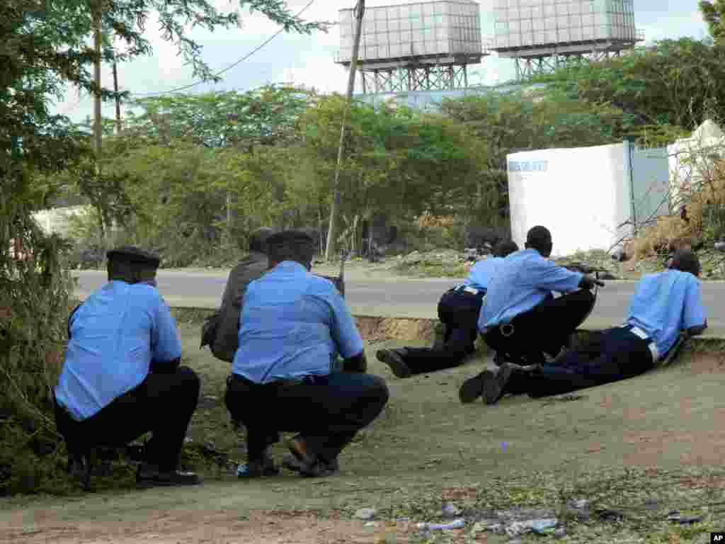 Kenyan police officers take cover outside Garissa University College during an attack by gunmen in Garissa, April 2, 2015.
