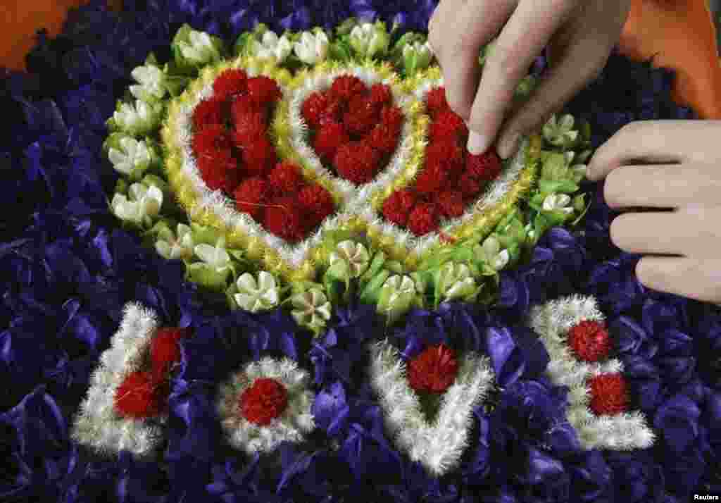 Seorang penjual mengatur karangan bunga bertuliskan &#39;Love&#39; untuk memperingati Valentine&#39;s Day di Kunming, provinsi Yunnan, Tiongkok. 