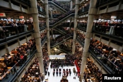 FILE - Lloyd's of London staff hold their annual Remembrance Day service at the Lloyd's building in the City of London, Britain, Nov. 11, 2015.