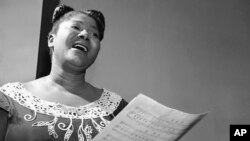 Mahalia Jackson, "Queen of the Gospel Singers," practices a new song in her Chicago apartment, Aug. 30, 1955. 