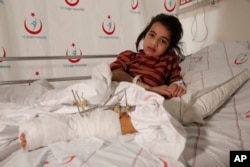 Syrian Aya Sharqawi, 6, wounded in an airstrike 10 days ago in her hometown of Tel Rifaat, Syria, lays on her bed at a hospital in Kilis, Turkey, Feb. 9, 2016.