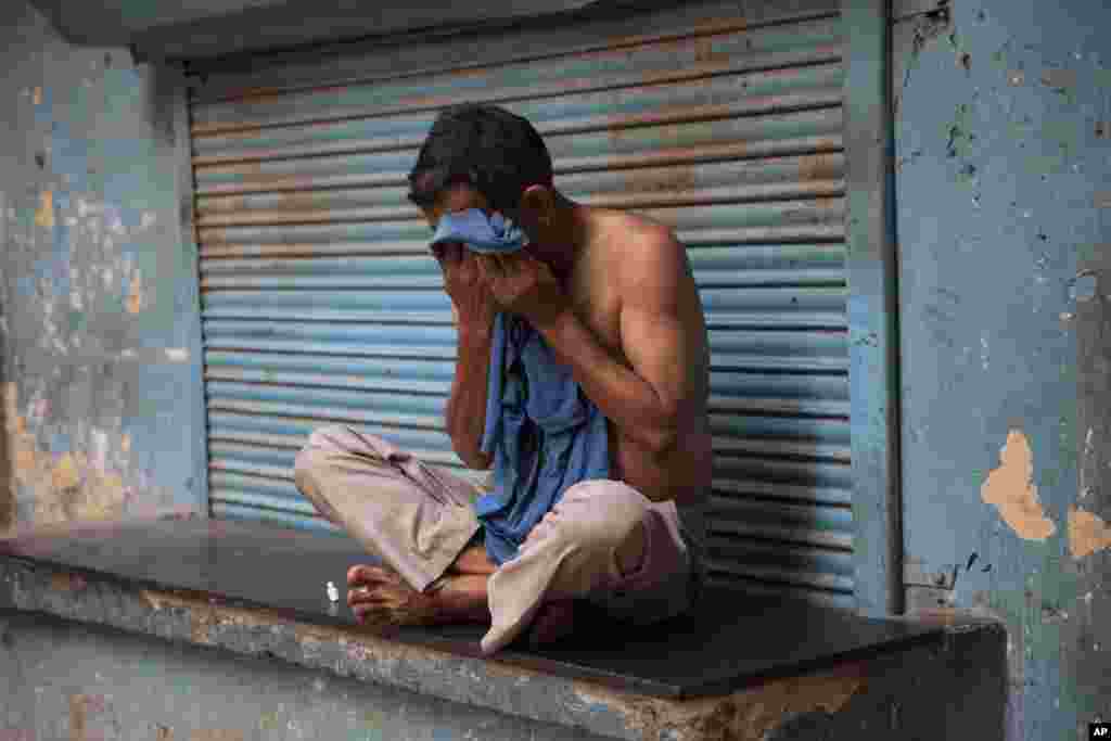 As a heat wave tightens its grip over most parts of the country, a man wipes sweat off his face in New Delhi, May 24, 2015.&nbsp;