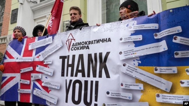 Activists hold a poster to thank the British government for support during a rally at the British embassy in Kyiv, Ukraine, Friday, Jan. 21, 2022. The UK sent 30 elite troops and 2,000 anti-tank weapons to Ukraine amid fears of Russian invasion.