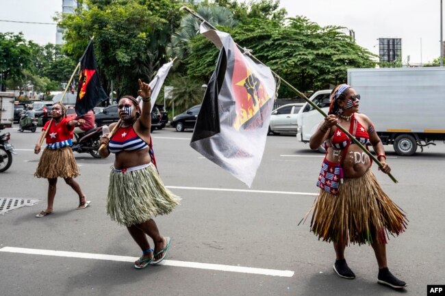 Aksi unjuk rasa mahasiswa Papua untuk kemerdekaan provinsi Papua, di markas polisi di Surabaya, 1 Desember 2021, bertepatan dengan hari jadi Gerakan Papua Merdeka (OPM). (Juni KRISWANTO / AFP)