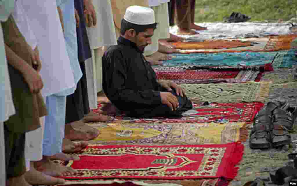 A disabled Afghan refugee offers prayers of Eid at Kacha Ghari camp on the outskirts of Peshawar, Pakistan, Aug. 30, 2011. AP