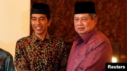 FILE - Indonesian President Susilo Bambang Yudhoyono shakes hand with Joko "Jokowi" Widodo during a meeting at the presidential palace in Jakarta, July 20, 2014. 