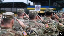 FILE - U.S. soldiers salute during the opening ceremony of the "Rapid Trident" international military exercises at training grounds outside Lviv, Ukraine, Sept. 3, 2018.