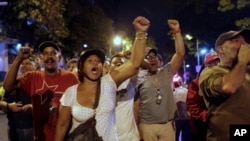 Des pro-Chavez scandent des slogans devant un bureau de vote de Caracas (14 avril 2013)