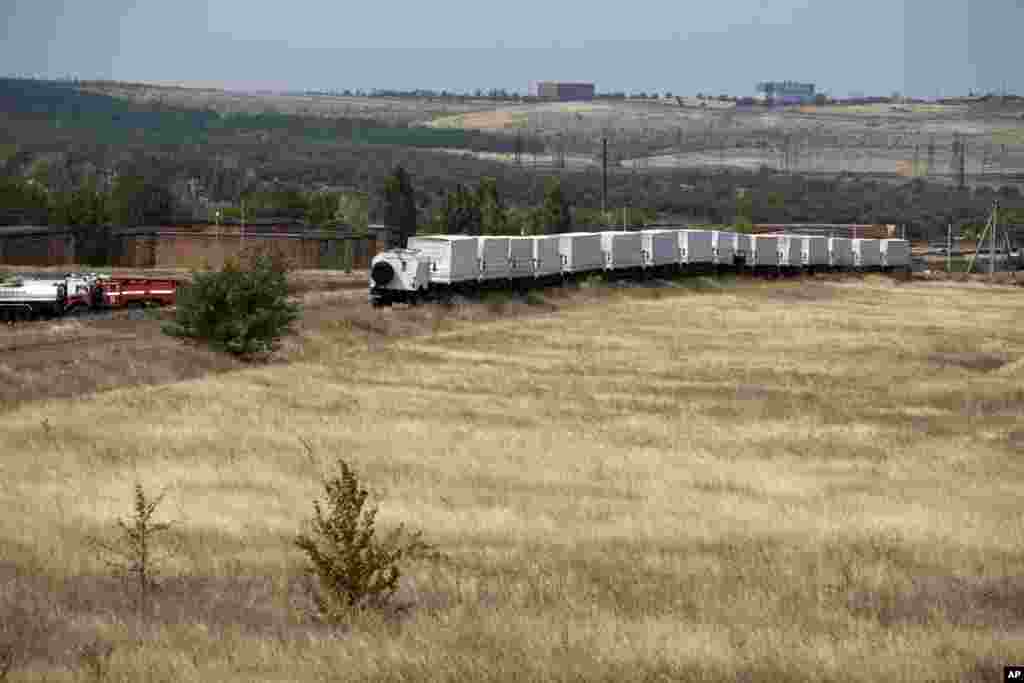 Sixteen trucks forming part of an aid convoy, wait in a field about 28 kilometers from a Russia-Ukraine border control point, Aug. 18, 2014.&nbsp;