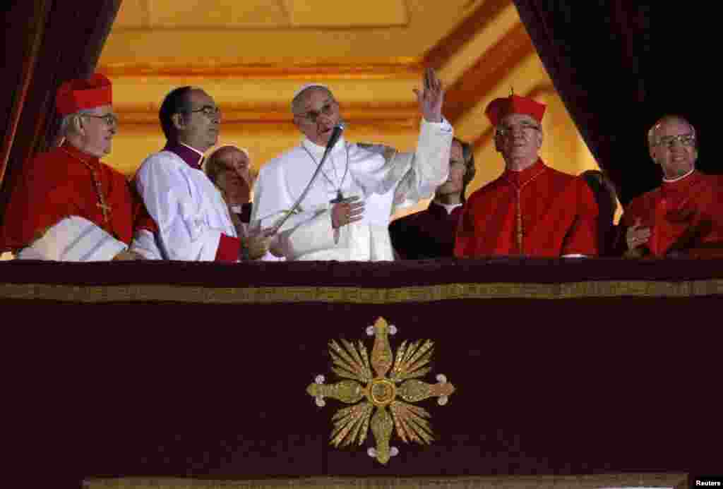Newly elected Pope Francis (C), Cardinal Jorge Mario Bergoglio of Argentina appears on the balcony of St. Peter's Basilica after being elected by the conclave of cardinals, at the Vatican, March 13, 2013. White smoke rose from the Sistine Chapel chimney a