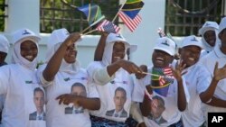 Des Tanzaniens applaudissant au passage du président Obama