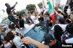 FILE - Demonstrators chant around a car during a demonstration against Republican U.S. presidential candidate Donald Trump after his campaign rally in San Jose, California, June 2, 2016.