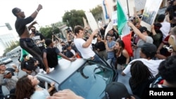 Demonstrators chant around a car during a demonstration against Republican U.S. presidential candidate Donald Trump after his campaign rally in San Jose, California, June 2, 2016.