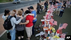People pray at a makeshift memorial for victims of a mass shooting Monday, Oct. 9, 2017, in Las Vegas. Stephen Paddock opened fire on an outdoor country music concert killing dozens and injuring hundreds. (AP Photo/John Locher)