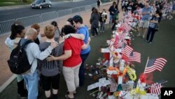 People pray at a makeshift memorial for victims of a mass shooting Monday, Oct. 9, 2017, in Las Vegas. Stephen Paddock opened fire on an outdoor country music concert killing dozens and injuring hundreds. (AP Photo/John Locher)