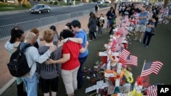 People pray at a makeshift memorial for victims of a mass shooting Monday, Oct. 9, 2017, in Las Vegas. Stephen Paddock opened fire on an outdoor country music concert killing dozens and injuring hundreds. (AP Photo/John Locher)