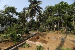 Seorang asisten Sayyed Munir Kamruddin, seorang penggali kubur, menyiapkan kuburan untuk penguburan korban COVID-19 di sebuah pemakaman di Mumbai, India 28 April 2021. (REUTERS / Francis Mascarenhas)