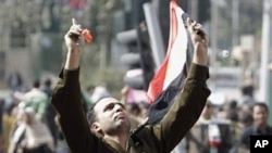 A man identified only as Fathi, wearing the uniform of a captain in the Egyptian army, is carried by demonstrators on Tahrir, or Liberation Square, in Cairo, Egypt, Monday Jan. 31, 2011