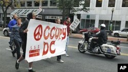 A police on a motorcycle passes a group of Occupy DC protesters as they march from McPherson Square to a Bank of America on K Street in Washington, October 20, 2011.