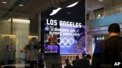 Journalists listen to a presentation at USC's Wallis Annenberg Hall, Los Angeles 2024's proposed site for the main press center,