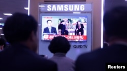 People watch a TV news report about the meeting between North Korean leader Kim Jong Un and Chinese President Xi Jinping at a railway station in Seoul, South Korea May 8, 2018. REUTERS/Kwak Sung-Kyung 