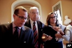Sen. Chuck Grassley, R-Iowa, center, walks past members of the media as he heads to the Senate floor on Capitol Hill in Washington, Tuesday, Sept. 18, 2018.