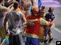 Boss clown Sandor Eke hugs fellow clowns as he holds his 2-year-old son after the red unit's final performance, May 7, 2017, in Providence, R.I. "The Greatest Show on Earth" is about to put on its last show on earth.