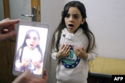 Syrian Bana al-Abed is filmed by her mother as they prepare to post on Twitter in English about life in the besieged eastern districts of Syria's Aleppo, Oct. 12, 2016.