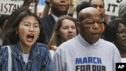 U.S. Rep. John Lewis, right, leads a march of thousands through the streets of Atlanta on March 24, 2018. Participants in Atlanta and across the nation rallied against gun violence and in support of stricter gun control.