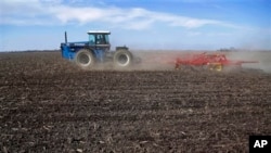 FILE - Central Illinois corn and soybean farmer cultivates field in preparation for spring planting, Waverly, Ill.