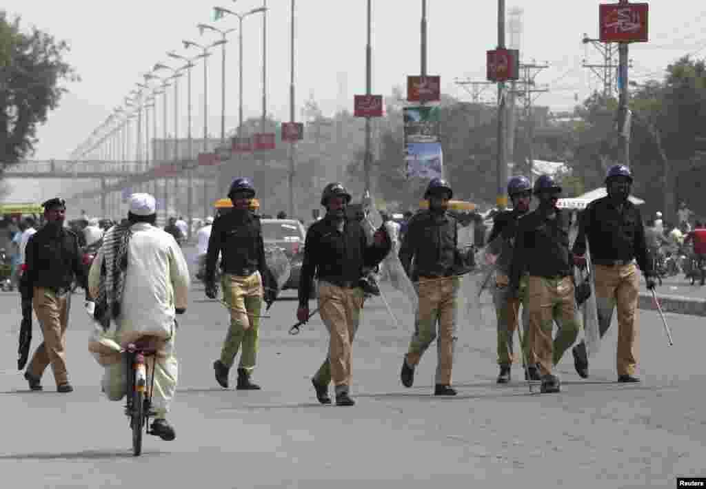 Policemen move to disperse residents after they threw stones at participants of the Freedom March, led by cricketer-turned-opposition politician Imran Khan, in Gujranwala, Aug. 15, 2014.