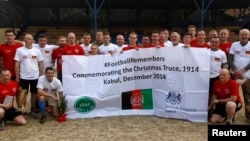 German and British troops pose for a photo after a football match to commemorating the Christmas Truce of 1914, at the ISAF Headquarters in Kabul, Dec. 24, 2014. 