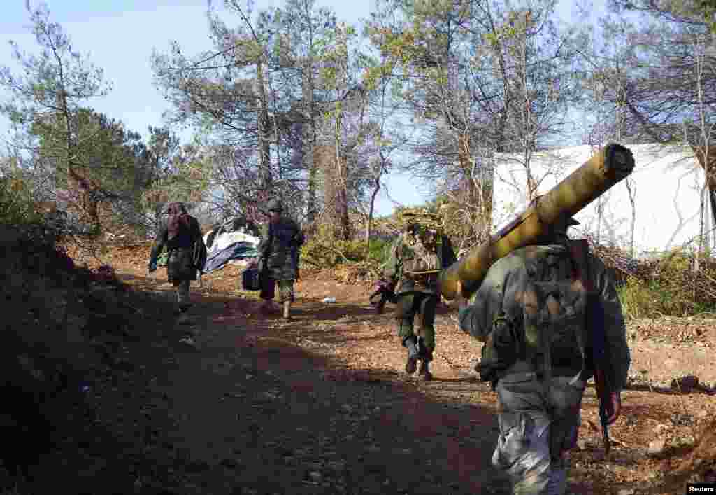 A rebel fighter carries an anti-tank weapon as he heads with his fellow fighters towards their positions in the Armenian Christian town of Kasab, Syria, April 23, 2014.