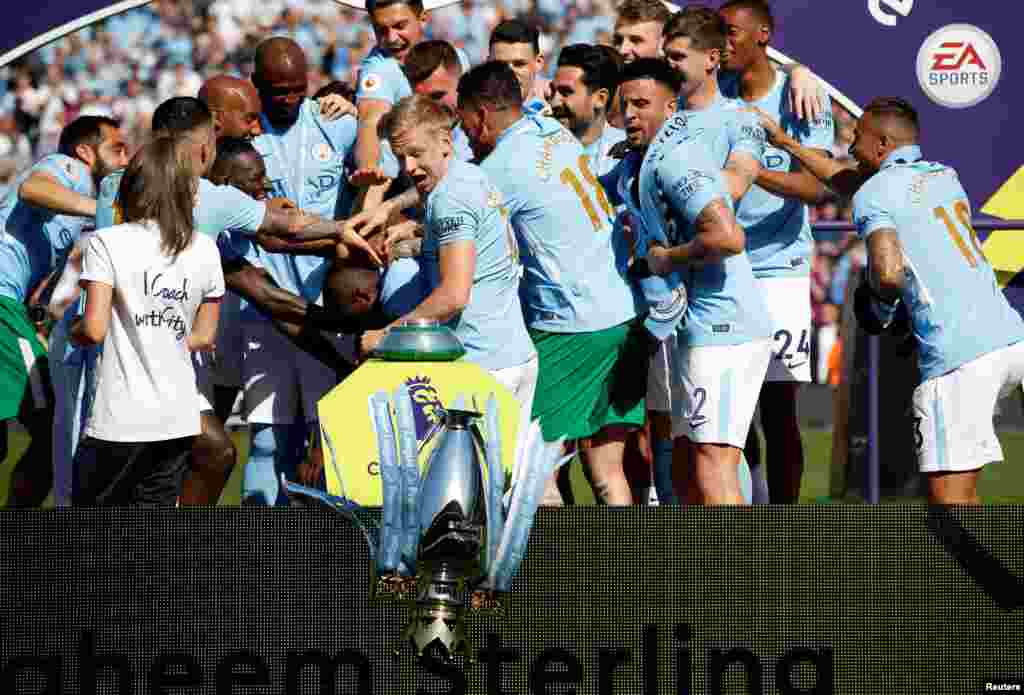 Manchester City's Oleksandr Zinchenko reacts as the trophy falls to the floor as players and staff celebrate winning the premier league title at the Etihad Stadium in Manchester, Britain, May 6, 2018.