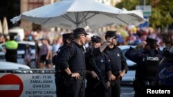 Police officers stand at a road block in Bilbao, Spain, Aug. 19, 2017.
