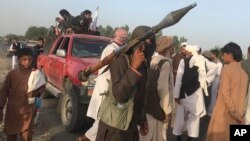 FILE - Taliban fighters gather in Surkhroad district of Nangarhar province, east of Kabul, Afghanistan, Saturday, June 16, 2018. Taliban seized Camp Chenaya in the Ghormach district of Faryab province late Monday following two days of intense fighting. 