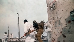 Chechen fighters running along the Lenin avenue under Russian fire in downtown Grozny on January 25, 1995. (Alexander Nemenov/AFP)