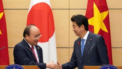 Thủ Tướng Nhật Shinzo Abe (phải) và Thủ Tướng VN Nguyễn Xuân Phúc bắt tay sau cuộc họp báo chung tại văn phòng Thủ Tướng Abe ở Tokyo hôm 8/10/2018. (AP Photo/Eugene Hoshiko, Pool) 