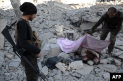 Turkish-backed Syrian rebels cover the body of an alleged Islamic State (IS) group fighter in the northwestern border town of al-Bab on February 23, 2017 after they fully captured the town from IS.