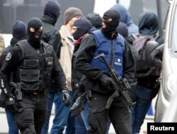 Belgian police stage a raid, in search of suspected Muslim fundamentalists linked to the deadly attacks in Paris, in the Brussels suburb of Molenbeek, Nov. 16. 2015.