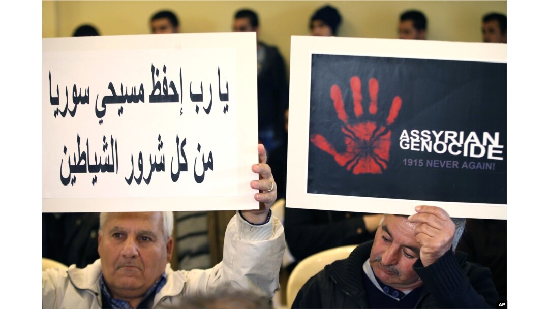 FILE - Assyrians citizens hold placards during a sit-in for abducted Christians in Syria and Iraq, at a church in Sabtiyesh area east Beirut, Lebanon, Feb. 26, 2015.