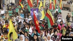 Syrian Kurds demonstrators hold flags and portraits of jailed Kurdistan Workers Party (PKK) leader Abdullah Ocalan during a protest in Derik, Al Hasakah, Syria, November 1, 2012.